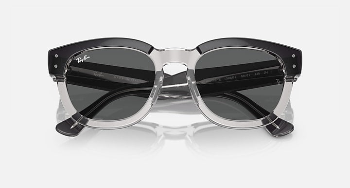 Sunglasses low-angle view with dark round lenses, transparent dark-gray frame and metal hinges