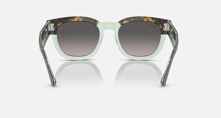 Transparent mint-green rounded sunglasses with dark lenses and metal nose bridge