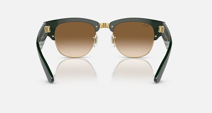 Green sunglasses with brown lenses and gold-toned metal details