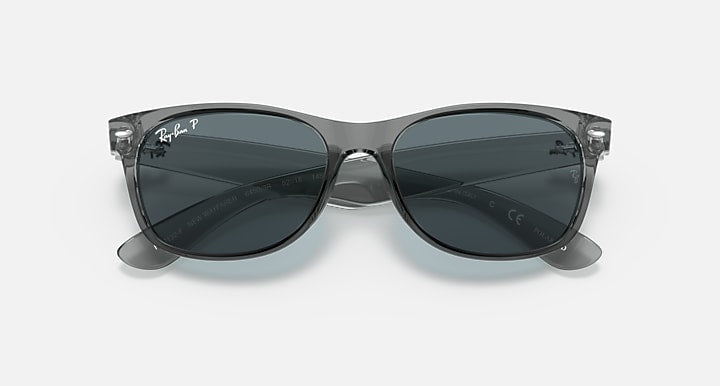 Clear grey Wayfarer-style sunglasses with dark lenses, front view, full-rim frame.