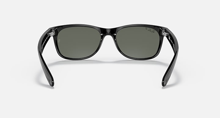 Ray-Ban Wayfarer sunglasses front view, black frame with dark green lenses and nose bridge.
