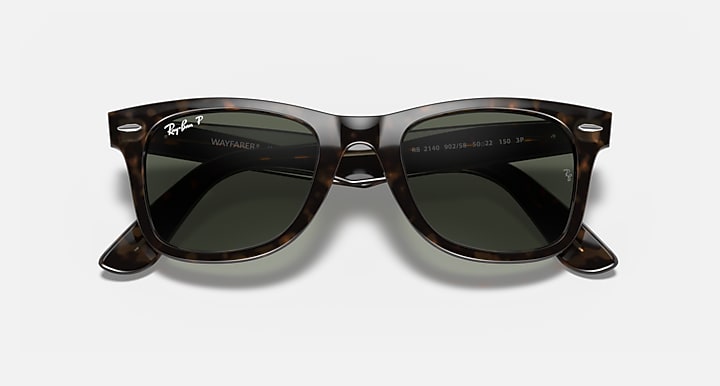 Tortoise Wayfarer sunglasses with dark green lenses and subtle lens reflections