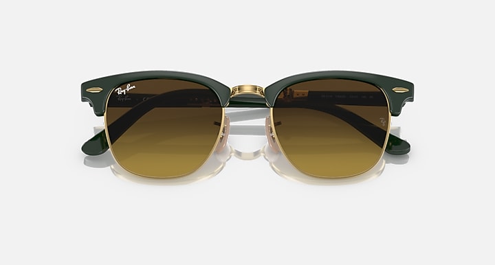 Folding sunglasses top view with dark green frame, gold bridge, brown-tinted lenses