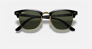 Ray-Ban sunglasses with dark green lenses, black frame, and gold-tone bridge