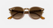 Light brown round sunglasses with brown lenses and orange temple tips