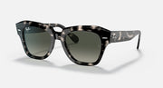 Black square sunglasses with green-tinted lenses and thick plastic frame, side profile