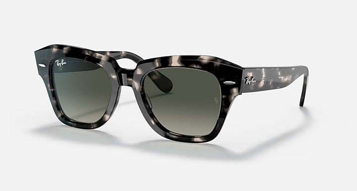 Black square sunglasses with green-tinted lenses and thick plastic frame, side profile