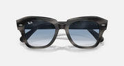 Black sunglasses, angled front view with blue lenses and glossy dark frame