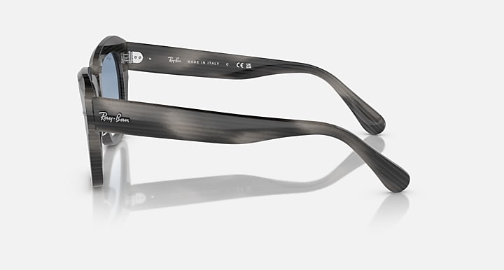 Black sunglasses, side view with blue lens and branded temple arm