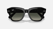 Black square-frame sunglasses with dark green-tinted lenses, front view.