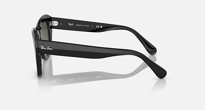 Black square-frame sunglasses, side profile with dark green lenses and branded temples.