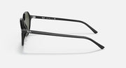 Black round sunglasses side view with dark green lenses and curved temples.