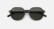 Round black sunglasses with dark green lenses and engraved markings on inner arms.