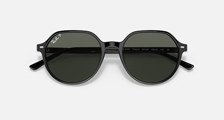 Round black sunglasses with dark green lenses and engraved markings on inner arms.