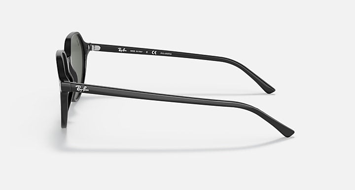 Black round sunglasses side profile with dark green lenses and straight temples.