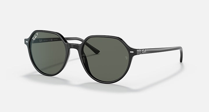 Round black sunglasses with dark green lenses, full rim, and curved arms.