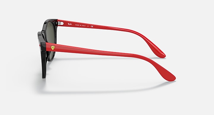 Black sunglasses with red temple arms and light green lenses, side view