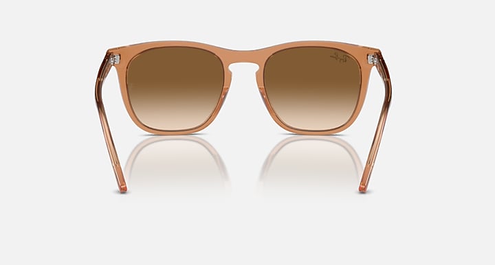 Transparent brown wayfarer-style sunglasses with clear gradient brown lenses and curved frame
