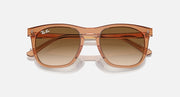 Transparent brown Ray-Ban wayfarer-style sunglasses with clear gradient brown lenses, front view