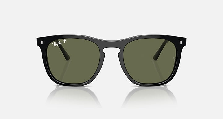 Black sunglasses with dark green lenses, close front view with angled temple arms