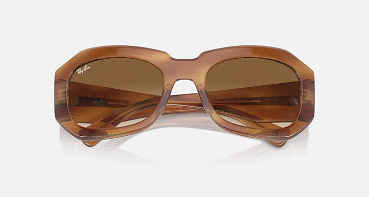 Brown sunglasses with dark amber gradient lenses, wide oval front view