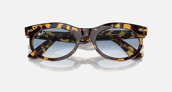 Ray-Ban Wayfarer oval sunglasses, tortoise-pattern frame with blue-tinted lenses angled view