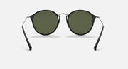 Round black sunglasses with dark green lenses and metal hinges, front angle view.