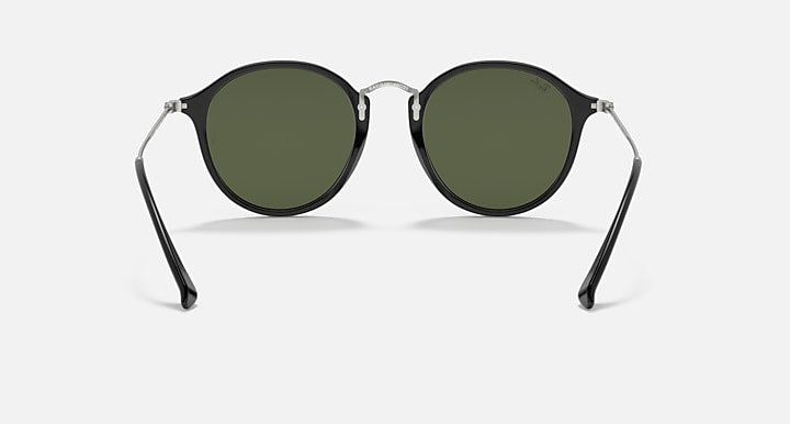 Round black sunglasses with dark green lenses and metal hinges, front angle view.
