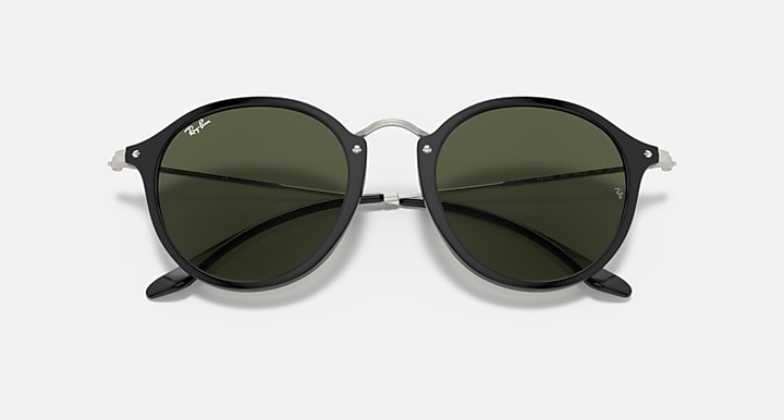 Round sunglasses with dark green lenses, black frame and metal bridge detail.