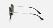 Side-profile sunglasses with metal arms and black temple tips, dark green lenses.