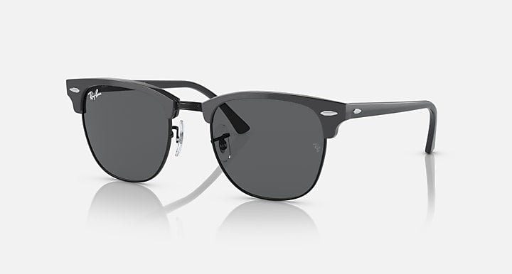 Clubmaster-style sunglasses with matte-black frame and dark lenses, gold-tone details