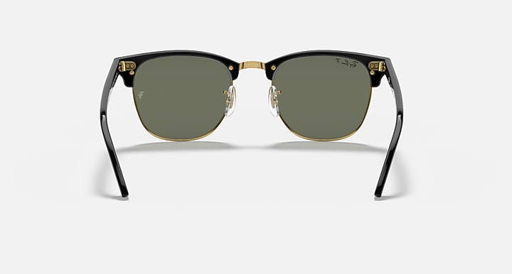 Clubmaster-style sunglasses front view; dark green lenses, rounded black frame, gold bridge