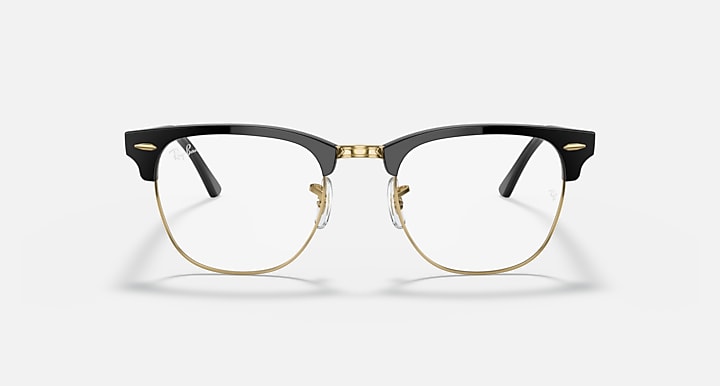 Clubmaster-style sunglasses with black frame, clear lenses, and gold-tone bridge detail