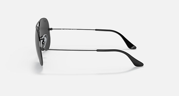 Ray-Ban aviator sunglasses with dark frame and green-tinted lenses, angled view