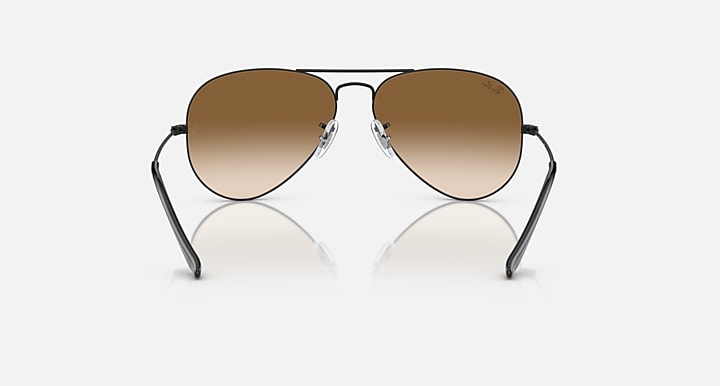 Ray-Ban aviator sunglasses with thin metal frame and warm brown tinted lenses.