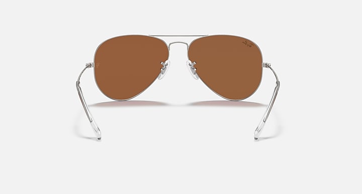 Ray-Ban aviator sunglasses with thin metal frame and brown tinted lenses.