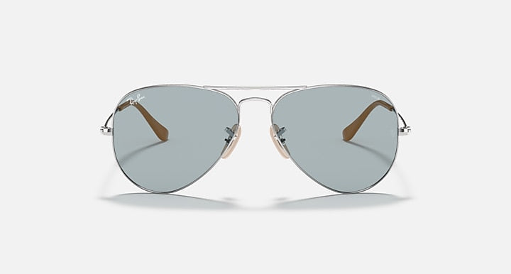 Ray-Ban aviator sunglasses with thin metal frame, light blue lenses, and brown accents.