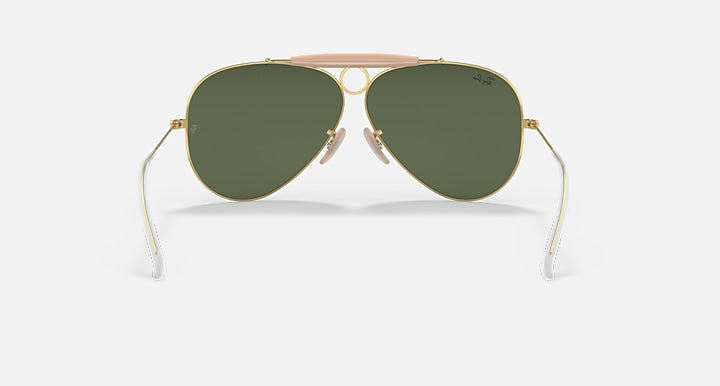 Ray-Ban aviator sunglasses with dark green lenses, gold frame, and pink top bar
