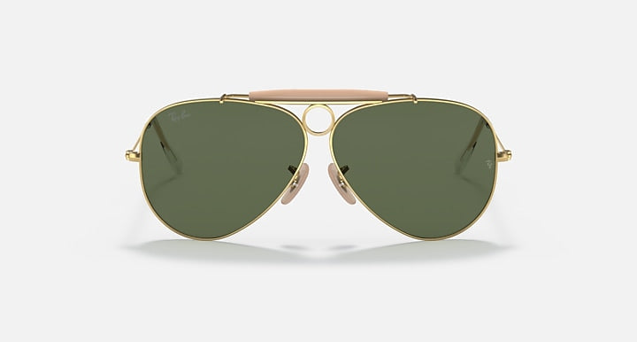 Ray-Ban aviator sunglasses with gold frame, dark green lenses, and pink bridge accent