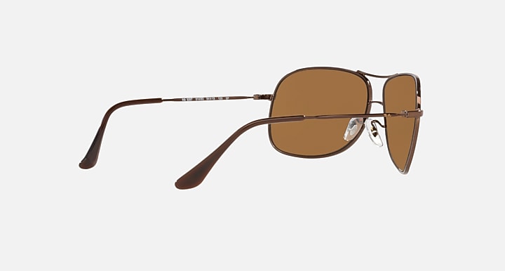 Ray-Ban aviator sunglasses angled side, brown lenses, gold-tone metal frame