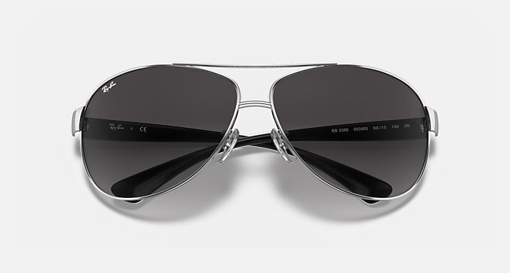 Aviator sunglasses with silver frame and dark gray gradient lenses, close front