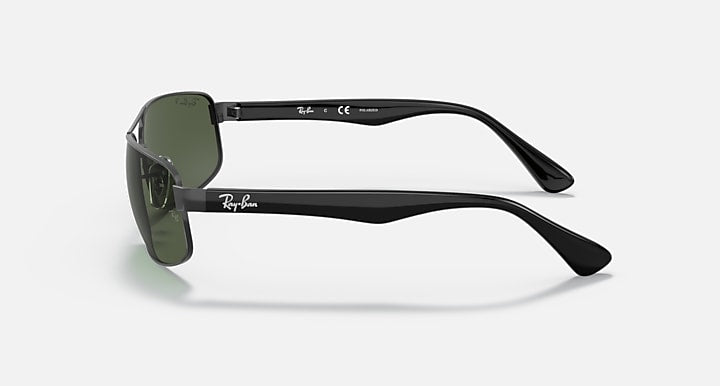 Side-profile sunglasses with black temples and dark green tinted lenses