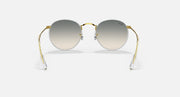 Round sunglasses with gold frame and gray tinted lenses, front view.