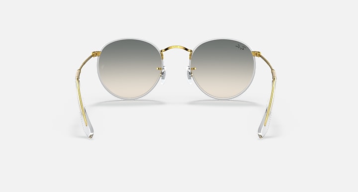 Round sunglasses with gold frame and gray tinted lenses, front view.