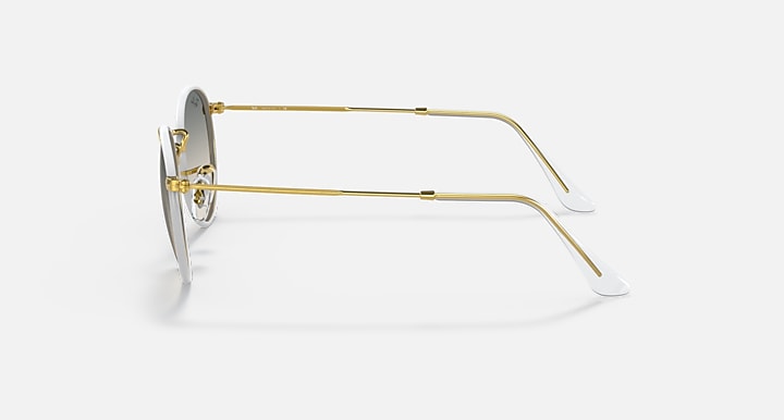 Gold metal sunglasses side view with round gray lenses and thin temples.