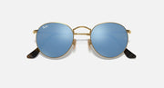 Round Ray-Ban sunglasses with gold frame, blue gradient lenses, black temple tips