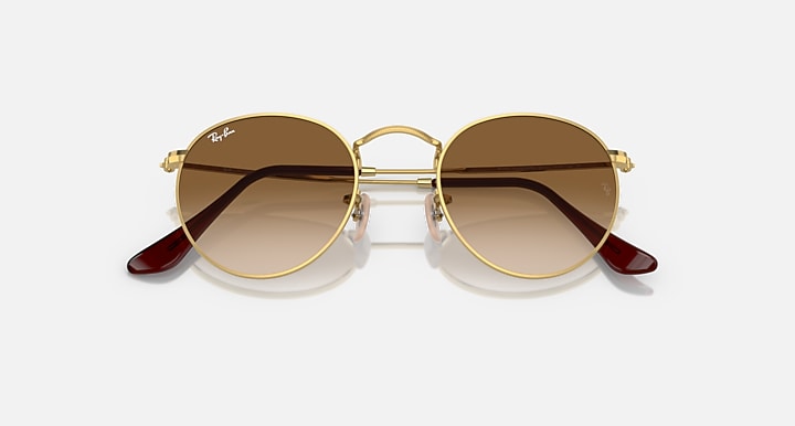 Ray-Ban round metal sunglasses with gold frame and dark brown tinted lenses