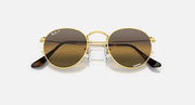 Round metal sunglasses with gold-tone frame, brown lenses, and dark temple tips