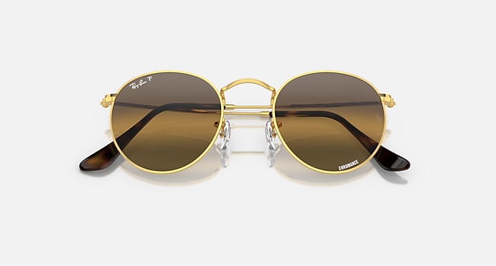 Round metal sunglasses with gold-tone frame, brown lenses, and dark temple tips