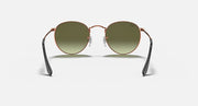 Round metal sunglasses with rose-gold frame, olive tinted lenses, black temple tips